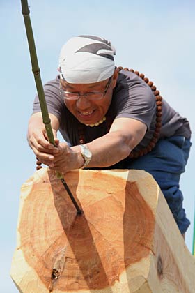 御柱の先端に吹き流しを取り付ける三条削ろう会会長の馬場さん