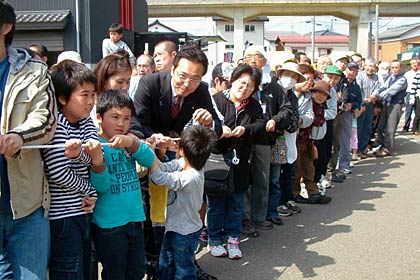 国定市長や南相馬市民も加わって綱を引いて御柱を立ちあげる