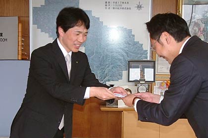 国定市長(右)に善意を手渡す「三軌苑を愛する会」事務局の早川さん(左)