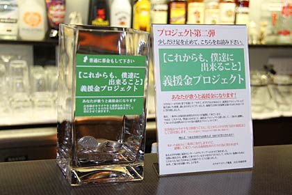 カウンターにガラスの義援金入れ