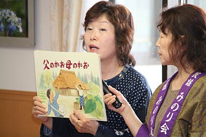 高齢者向け絵本『父のかお母のかお』を見せる小越さん