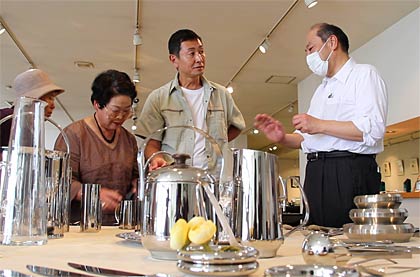 ショールームで説明する小林工業の小林社長(右)