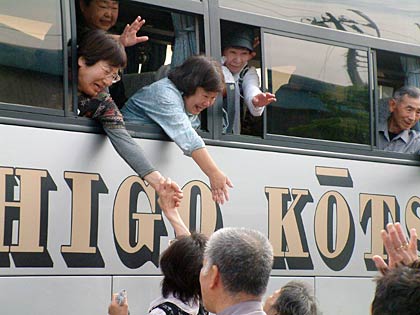 避難所のソレイユ三条でバスの車上から見送りの人たちとの別れを惜しむ帰郷する南相馬市民
