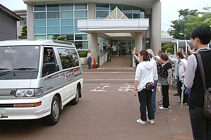 三条市の避難所の再編で29日、閉鎖された「ソレイユ三条」で体育センターへ移動する人たちを見送る市民やボランティア