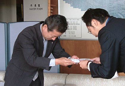国定三条市長に100万円の寄付を手渡すスノーピークの阿部管理本部長