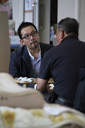 三条市総合福祉センターに開設された避難所で班長に取材する相場さん