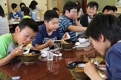 山吾食堂でカレーラーメンを試食する月岡小6年2組