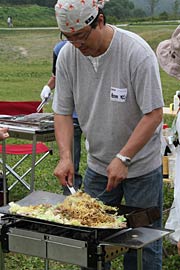 鍬焼きで焼きそばをふるまう相田合同工場の相田社長