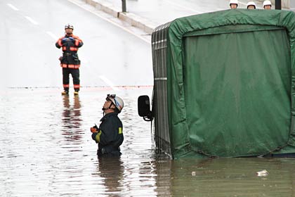 燕市井土巻地内のJR弥彦線のアンダーパスで立ち往生するトラック、水深約1メートルで腰までつかる消防職員