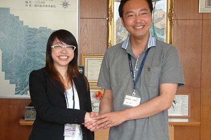  離任のあいさつに訪れて国定三条市長と握手する三条市国際交流員のヴィエン・ウォン