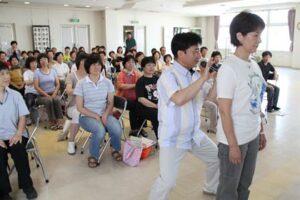 吉田ボランティア連絡協議会主催のタッピング・タッチ講習会に予想を超す62人が参加して指先で体をたたいて心と体を癒すテクニックを学ぶ