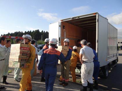 トラックから救援物資をヘリへ