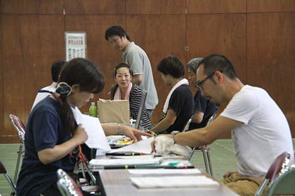作業を終わって書類に記入するボランティア