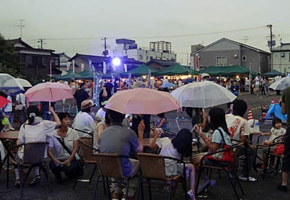 あいにくの雨で傘がたくさん開いた会場