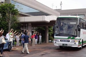 三条市総合福祉センターから被災者を乗せて南相馬市へ向けて出発するバスを見送る