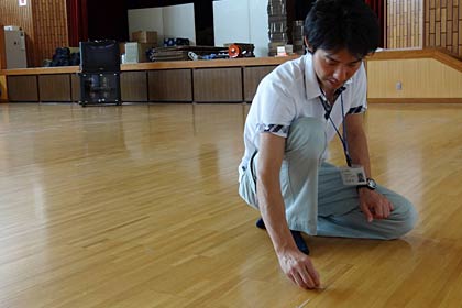 片付いた多目的センターで床のガムテープをはがす遠藤さん