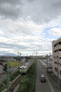 燕市井土巻地内で弥彦線の跨線橋上から燕三条駅側、台風から延びる雲が空を覆う