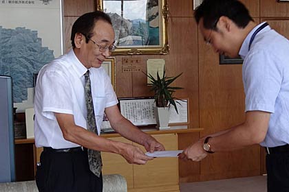  14日、三条市長に10万円余りの水害義援金を手渡す浅野タンスの浅野社長