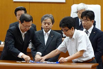 記名投票された賛成の白票と反対の青票を数える