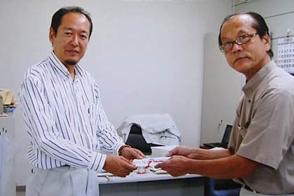 三条昭栄通り商店街からの義援金を陸前高田市の戸羽市長(左)に手渡す箕輪会長(右)