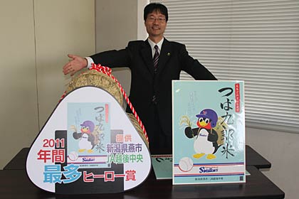 11月7日に発売する「つば九郎米」のパッケージデザインと(右)と年間最多ヒーロー賞(左)を紹介、アピールする鈴木燕市長