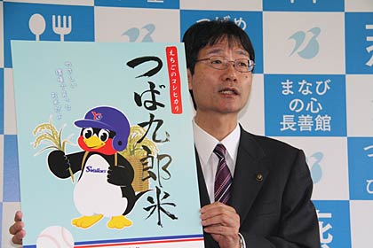 つば九郎米のパッケージデザインを手に燕市長