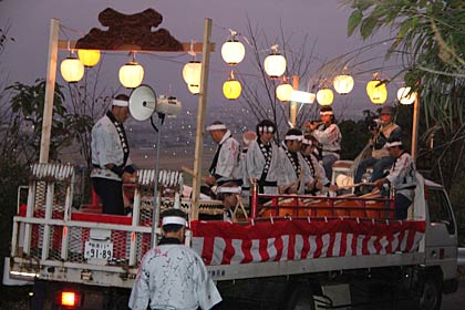 行列の先頭を行く分水太鼓を乗せた山車、眼下にはあかりがともり始めた分水地区が広がる