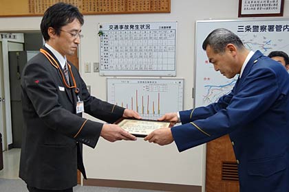 富岡三条署長(右)から感謝状を受ける三条本町一郵便局の蝶名林課長代理