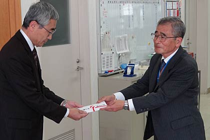 三条市社会福祉協議会の小林事務局長(左)にナノミストサウナ「ナノリッチ」2台の目録を手渡す崎山さん(右)