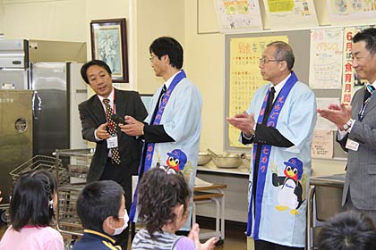 鈴木市長と菊地市長の2人がつば九郎米の宣材のはっぴを着て児童の給食に同席