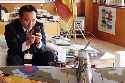 スピットファイアの6分の1モデルを前に目をきらきらさせて写真を撮る国定市長