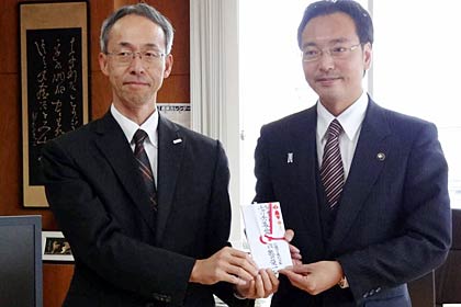 三条市の社会福祉にと7万円余りを国定市長(右)に手渡した北陸ガスの岩崎長岡支社長(左)