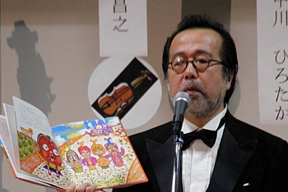 『りんごちゃんとビートルカード』を歌と演奏をまじえて読み聞かせる中川さん