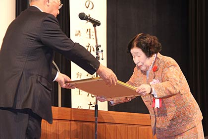 燕市社会福祉協議会の法人合併5周年福祉大会で青柳市社協会長から燕地区ボランティア連絡協議会への表彰状を受ける竹野会長