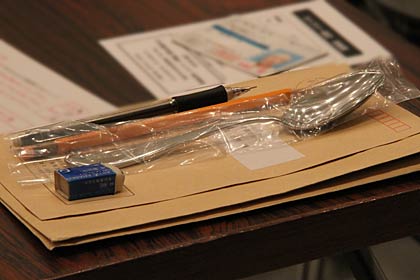受検者は参加記念品のスプーンを机に置いて4択のマークシートに向かう