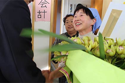 国定市長に花鉢を手渡して握手する双葉食堂の豊田さん