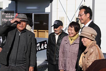 福島県南相馬市・双葉食堂で三条市に避難していた人たちから次々と記念写真や握手を求められる国定市長