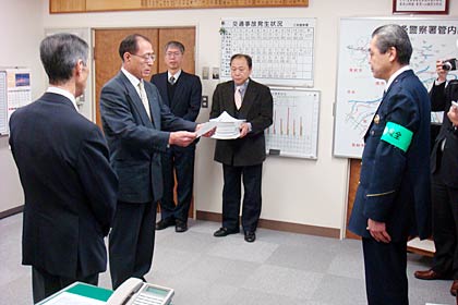 富岡三条署長に向かって交通安全宣言書を読み上げる三条市安協の金川部会長