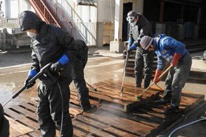 三条信用金庫の職員16人が宮城県石巻市・水産加工品メーカー「木の屋石巻水産」で木製パレットの洗浄などのボランティア活動