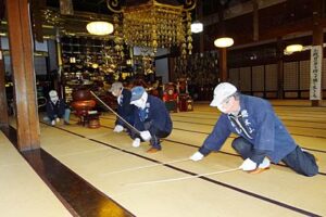 法華宗総本山本成寺で行われたすす払い、本堂の畳をタケの棒でたたく