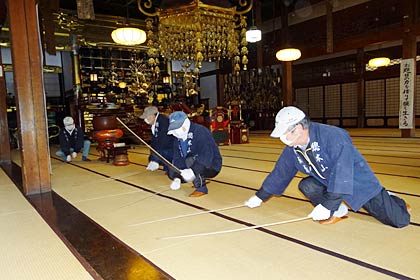 法華宗総本山本成寺で行われたすす払い、本堂の畳をタケの棒でたたく