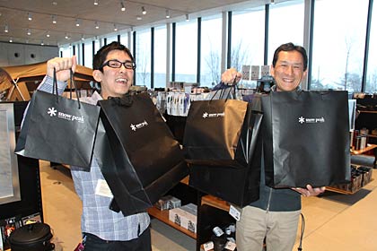  スノーピーク本社ストアで福袋を手に久保店長(左)と上原フィールドインストラクター(右)