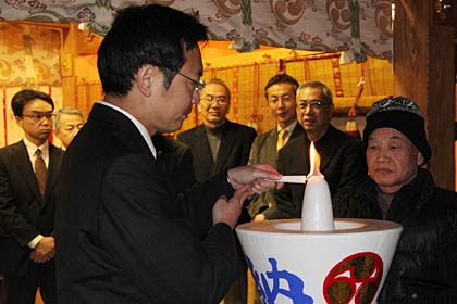 ろうそくに点火する国定市長