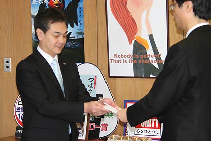 鈴木市長(右)にグリーンマネーからの寄付4万7,624円を手渡すホクエツの浅野社長(左)