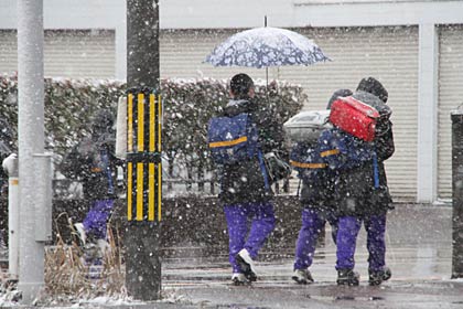 燕市大曲で風吹のなか背中を丸めて帰りを急ぐ中学生