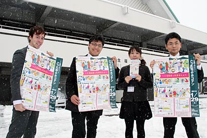 29日に1月の三条マルシェが開かれる三条市厚生福祉会館前でポスターを手に担当の地域経営課職員