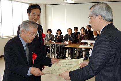 国土交通省北陸地方整備局の前川所長(右)から手づくり郷土（ふるさと）賞認定証を受けるポケットパーク整備実行委員会の石田委員長と国定三条市長