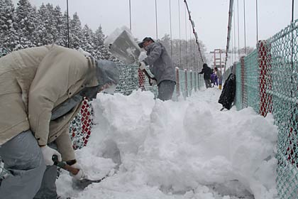 手すりの上までスコップで雪を持ち上げるのは重労働
