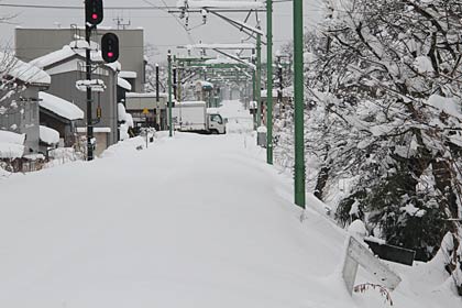 燕市分水史料館裏手の小学校踏切から見た越後線、線路は雪ですっぽりと覆われた