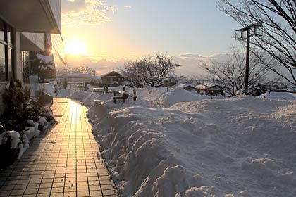12日夕方の三条市保内公園前の通路を光らせる夕日